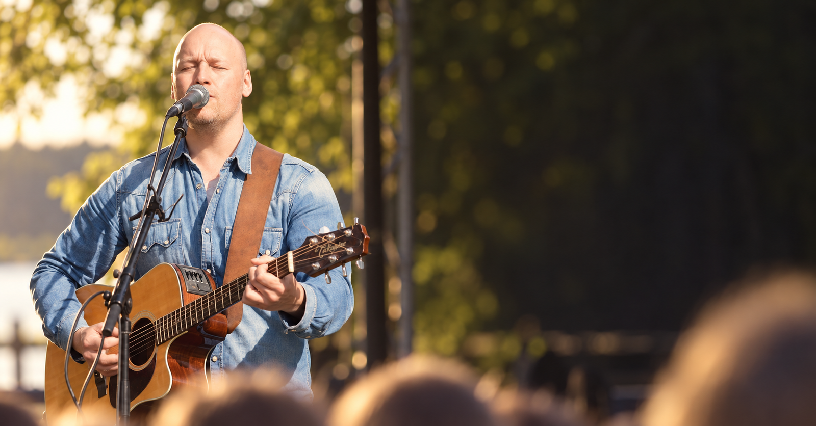 Daniel Hagman spelar gitarr och sjunger vid ett utomhusevenemang